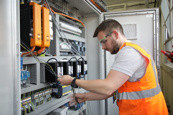 An engineer completing electrical install of control panel.