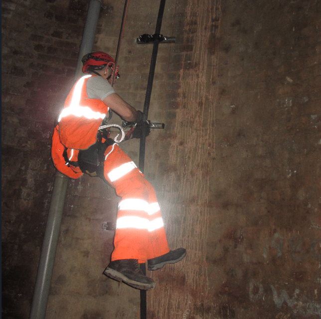 engineer installing cable hanging by safety harness