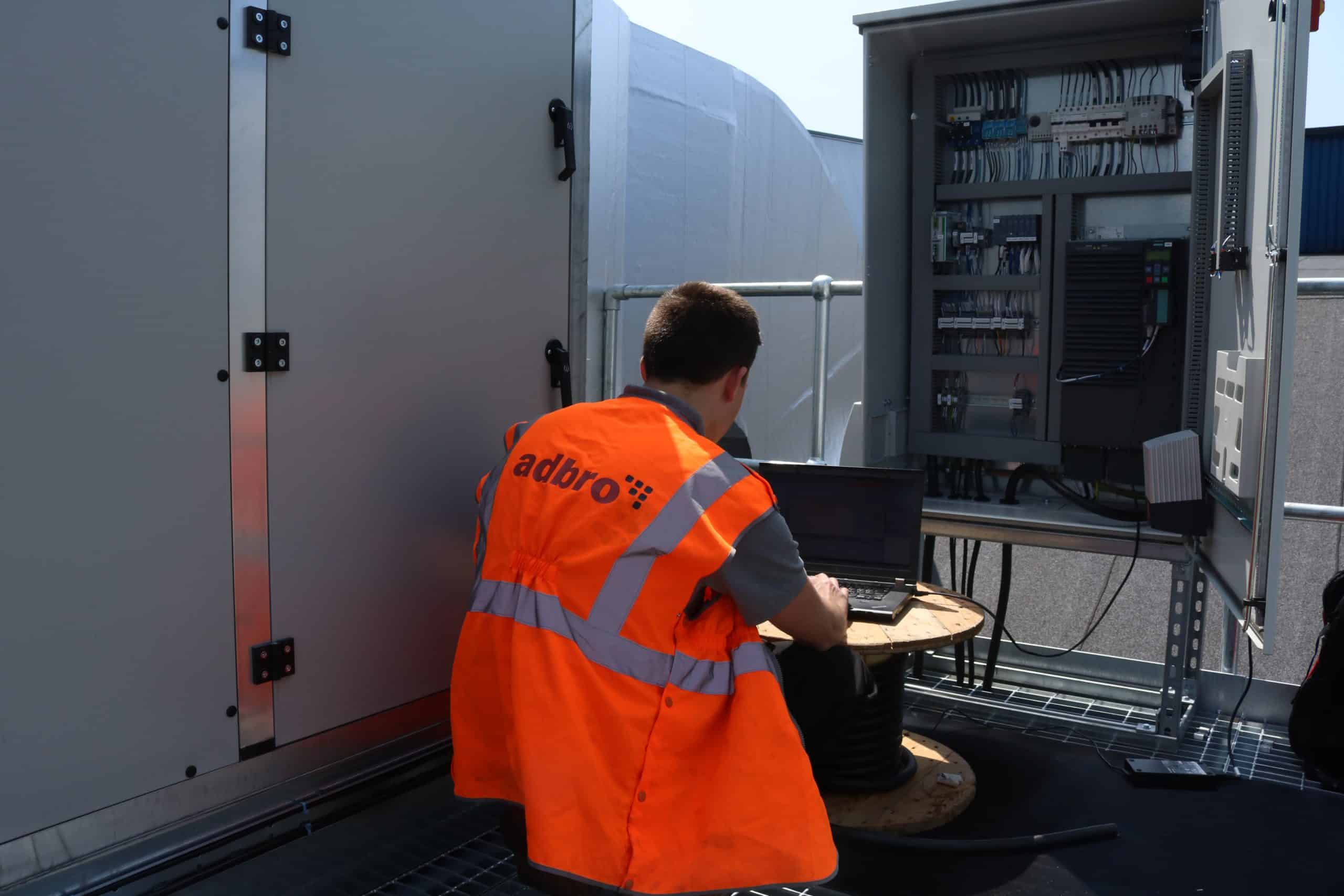 Engineer infront of a control panel providing maintenance and support.